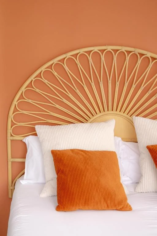 Rattan headboard and warm peach bedroom at SUPERTUBOS HOUSE Peniche