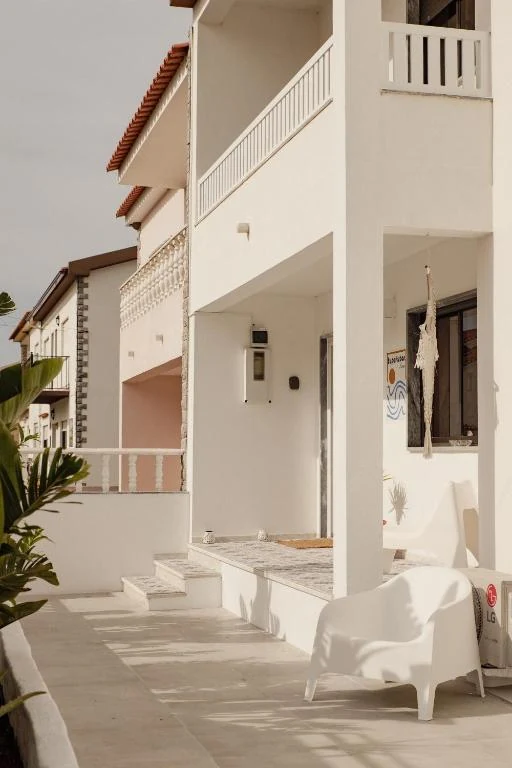White facade and relaxing terrace of Supertubos House